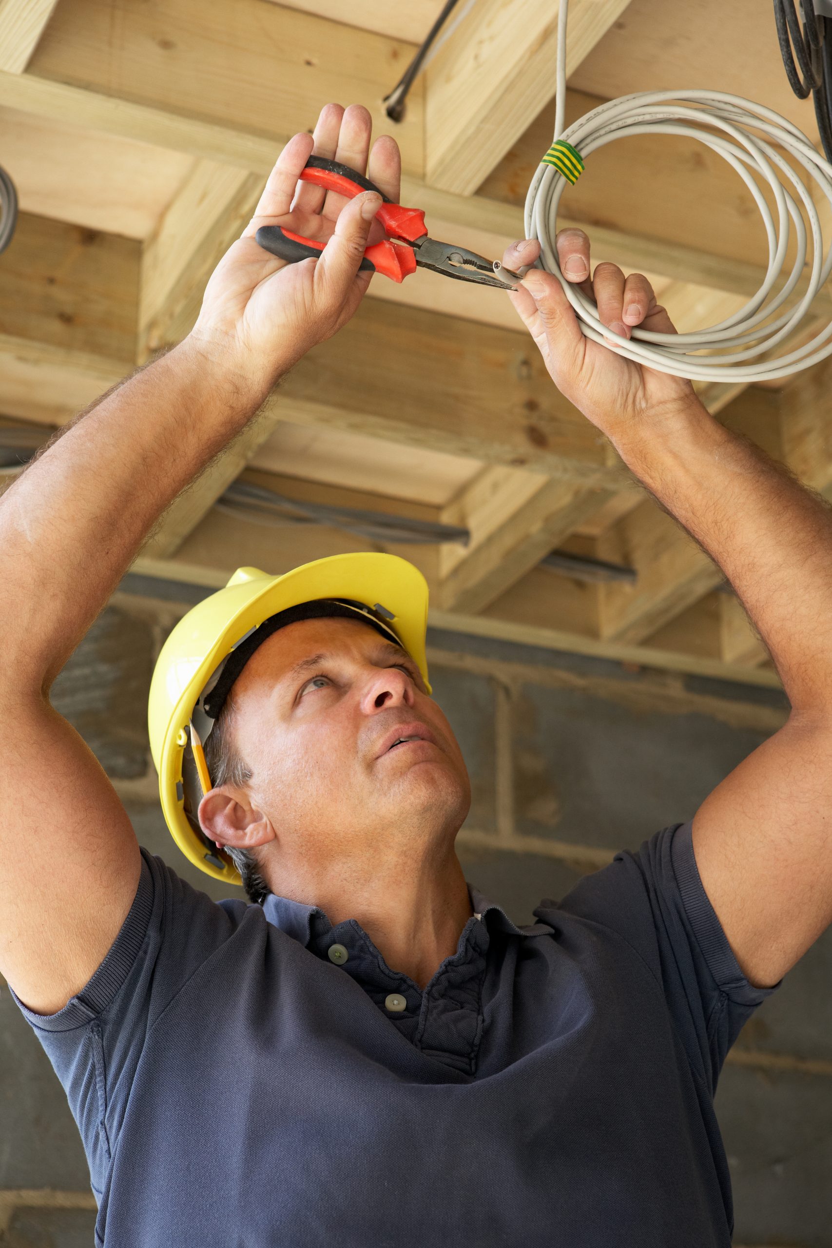 Electrician working in a ceiling.